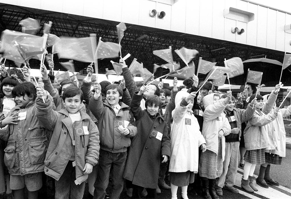 Enfants agitant des drapeaux européens pour marquer la disparition de la frontière entre l'Espagne et le Portugal (4 mars 1988)